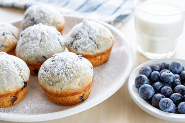 Homemade freshly baked muffins with blueberries on the plate and glass of milk