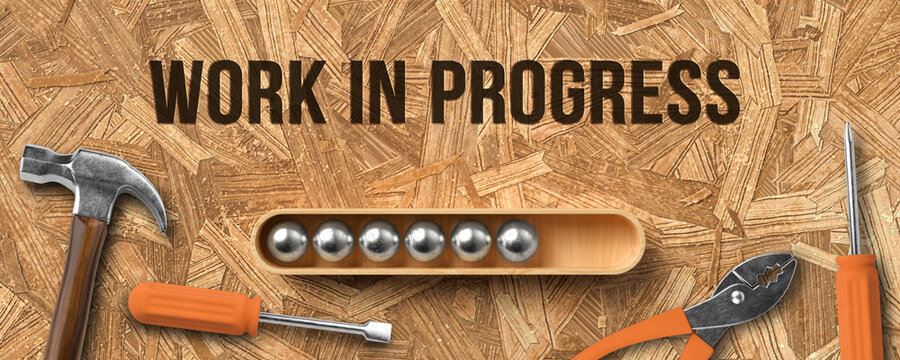 stylized loading bar with message WORK IN PROGRESS and handyman tools on wooden background