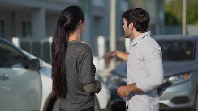 Two angry motorists arguing after a car accident on the road calling insurance company on mobile phone to responsibility for car accident traffic collision. furious driver man shouting to stress woman