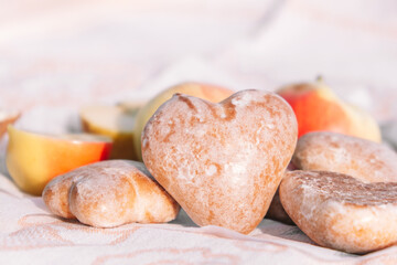 Glazed gingerbread cookies in the shape of heart.Picnic in nature, light snack with apples and cookies.Selective focus.