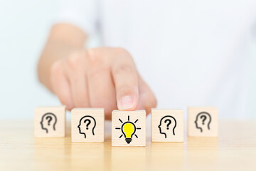 Concept creative idea and innovation. Hand choose wooden cube block with head human symbol and...