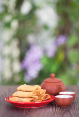 A plate of fried spring rolls and teapots