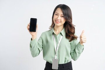 Fototapeta premium Beautiful Asian businesswoman holding smartphone with blank screen in hand
