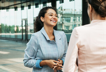 Business, people and lifestyle concept: Two diverse businesswomen. Excited afro female sharing...