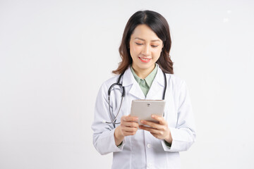 Portrait of asian female doctor using tablet standing smiling on white background