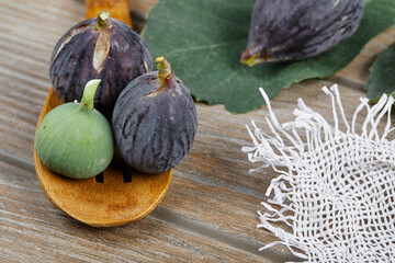 Ripe figs with a wooden spoon on a wooden table
