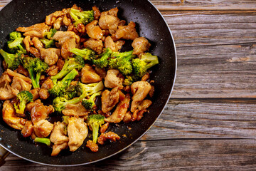 Stir fry with chicken and broccoli on wok. Chinese food.