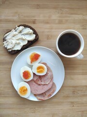eggs, ham, cheese, bread and coffee for breakfast on the wood