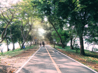 Defocused, out of focus, blurry image, people exercising in the park. On a bright day, people have outdoor activities.
