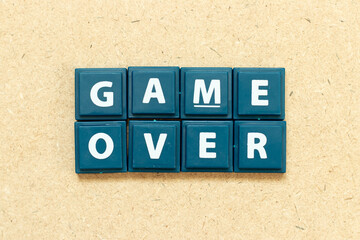 Tile alphabet letter in word game over on wood background