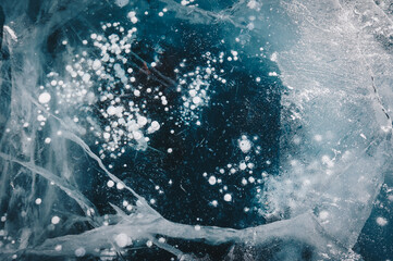 Beautiful cracks surface of the frozen lake of Baikal lake with frost methane bubbles in winter...