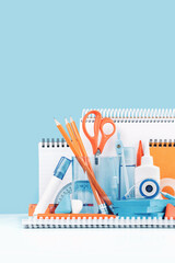 Group of office and school yellow orange and light blue stationery on desk. Close up. Various supplies for back to school or education and craft concept. Selective focus. Copy space banner