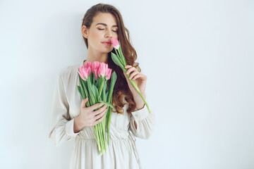 Beautiful woman with tulips. Spring bouquet in the hands of a young and happy girl. High quality...
