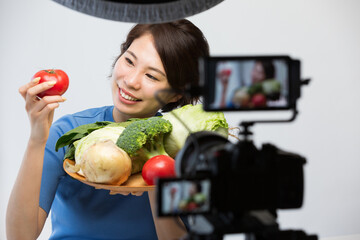 一眼レフカメラで動画を撮影する女性