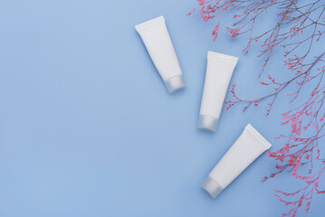 White tubes of cream on a blue background