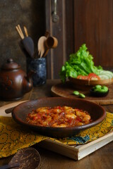 a plate of prawn cooked in sambal in an earhenware plate named gami udang is an Indonesian cuisine from Bontang, Borneo.