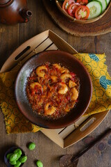 a plate of prawn cooked in sambal in an earhenware plate named gami udang is an Indonesian cuisine from Bontang, Borneo.