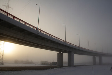 Severe frost and heavy fog on the road. Abnormal frosts in the city, fog is on the streets. Bridge 'Red Dragon' in Khanty-Mansiysk