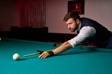 male billiard player finding best solution and right angle at billard or snooker pool sport game, professional billiard player is concentrated - obrazy, fototapety, plakaty