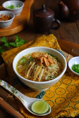 a bowl of Indonesian clear soup named soto Kudus, it contains of rice, vegetables and chicken meat