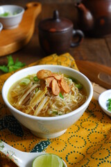a bowl of Indonesian clear soup named soto Kudus, it contains of rice, vegetables and chicken meat