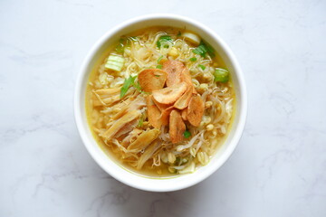 a bowl of Indonesian clear soup named soto Kudus, it contains of rice, vegetables and chicken meat