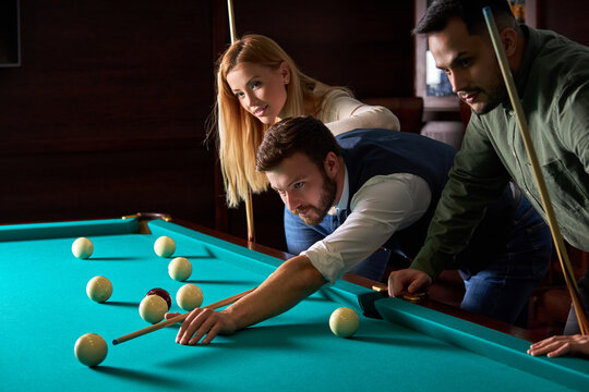 male billiard player finding best solution and right angle at billard or snooker pool sport game, he is concentrated