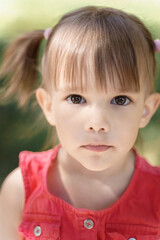 portrait of an emotional 3-year-old girl with black expressive eyes. serious smart look