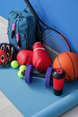 Set of sports equipment on floor near color wall © Pixel-Shot