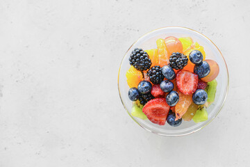 Bowl with fruit salad on light background