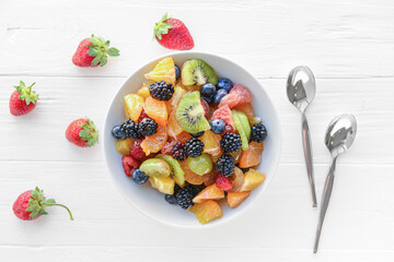Bowl with fruit salad on light background