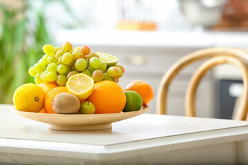 Plate with different fruits on kitchen table