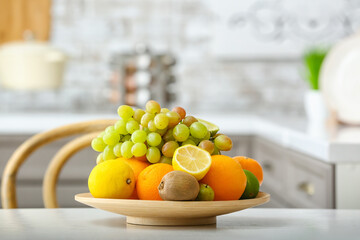 Plate with different fruits on kitchen table