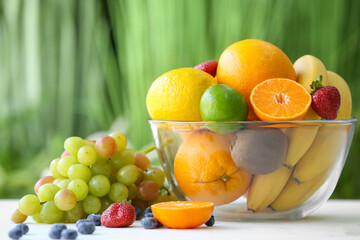 Bowl with different fruits and berries on table outdoors