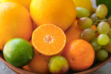 Obraz na płótnie Canvas Bowl with different fruits on table, closeup