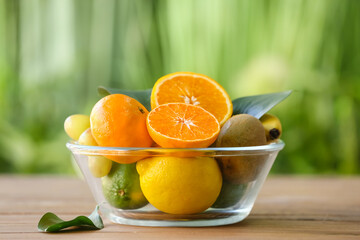Bowl with different fruits on table outdoors