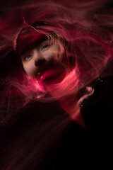 Portrait of young woman amid light painting , Over Black Background. Long exposure photo without photoshop, light drawing at long exposure