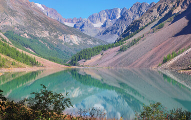 A picturesque lake in the Altai mountains. Morning view, beautiful reflection and amazing water color.