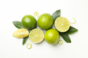 Ripe lime, leaves and peel on white background