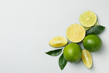 Ripe lime with leaves on light gray background
