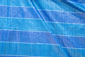 Blue Tarpaulin In Strong Sunlight. Stock Photo. Backgrounds.