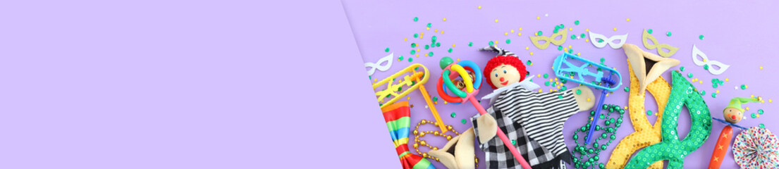 Purim celebration concept (jewish carnival holiday) over wooden purple background. Top view, flat lay