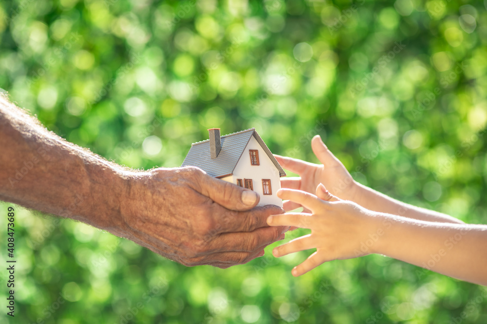 Canvas Prints family holding eco house in hands against spring green background