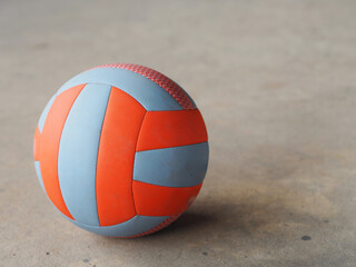 volley ball placed on the concrete ground, blue and orange color