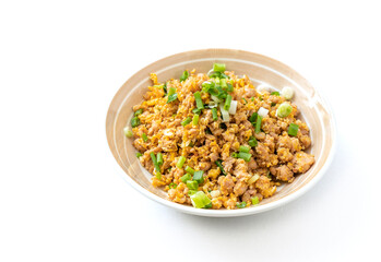 Stir-fried ground pork with egg in beautiful round dish, garnish with spring onions. Easy Asia homemade food for kid in Thailand, food image on white background.