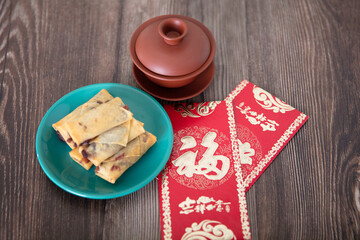Fried spring rolls, tea and red envelopes on the table at the beginning of spring in China