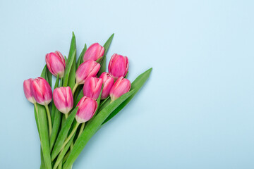 Spring mockup with pink tulips on blue background. Easter concept. Copy space. Top view - Image