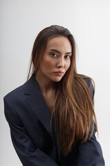 Obraz premium portrait of young attractive asian woman with long hair in blue suit isolated on white background. skinny stylish pretty female posing at studio. model tests of beautiful lady