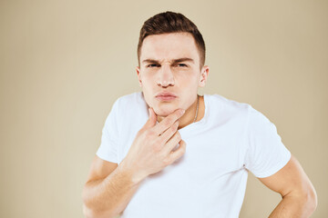 Emotional man facial expression gesture with hands white t-shirt beige background