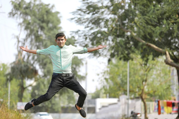 Young indian man Jump in air after achieving success.